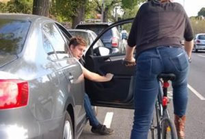Abriendo puerta de coche mientras se aproxima ciclista